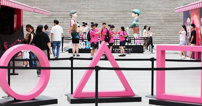 서울 종로구 광화문광장에 마련된 넷플릭스 시리즈 오징어게임 시즌3 팝업을 찾은 시민들이 드라마 조형물을 관람하고 있다./뉴스1