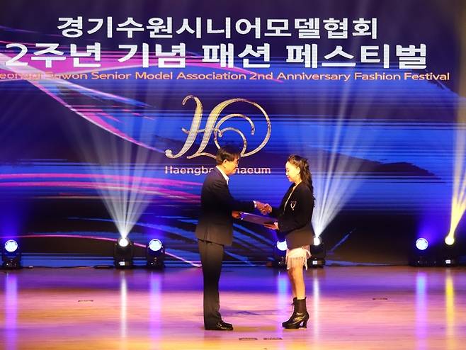 김봉식 수원문화원 원장이 지난 3일 빛누리아트홀에서 열린 '행복채움 2주년 기념 축제 패션쇼'에서 수상자에서 상을 전달하고 있다. 사진=수원문화원