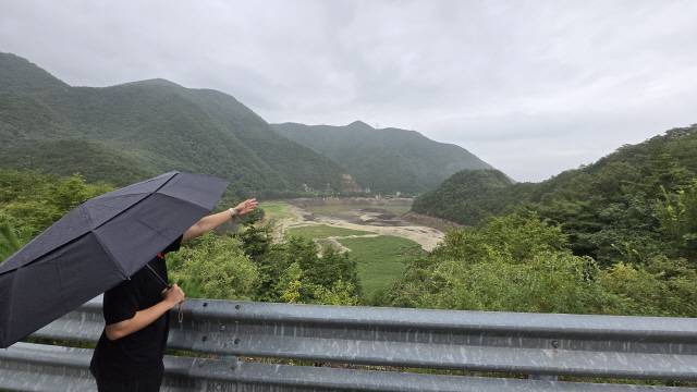 ▲ 강릉지역에 여우비가 내린 4일 시민이 맨바닥이 드러난 오봉저수지를 바라보고 있다. 이연제 기자