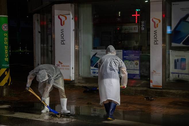 군산시 공무원들이 7일 새벽 기록적인 폭우로 침수 피해를 입은 나운동·문화동 일대에 급파돼 주민과 함께 쓰레기를 치우거나 배수 작업을 돕고 있다. 사진 군산시