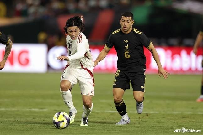 미나미노 타쿠미(왼쪽)가 7일 오전 11시(한국시간) 미국 캘리포니아주의 오클랜드 알라메다 카운티 콜리세움에서 열린 멕시코와 친선경기에서 드리블 돌파하고 있다. /AFPBBNews=뉴스1