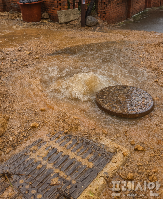 ▲7일 전주시 덕진구 한 도로 하수구 멘홀에서 빗물이 역류하며 뚜껑이 열리고 주변에 토사가 쌓여 있다. ⓒ제보자 제공
