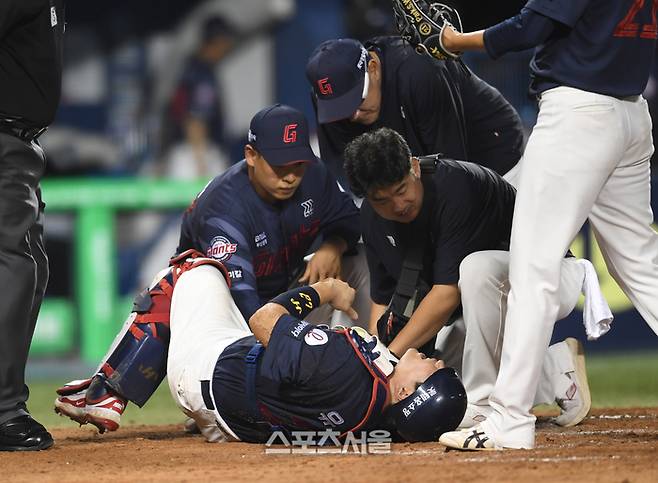 롯데 포수 유강남(아래)이 2일 잠실구장에서 열린 2025 KBO리그 LG와 경기 5회말 LG 오스틴의 파울팁 타구에 무릎을 맞은 뒤 고통스러워하고 있다. 유강남은 부상으로 손성빈으로 교체되었다. 잠실 | 박진업 기자 upandup@sportsseoul.com