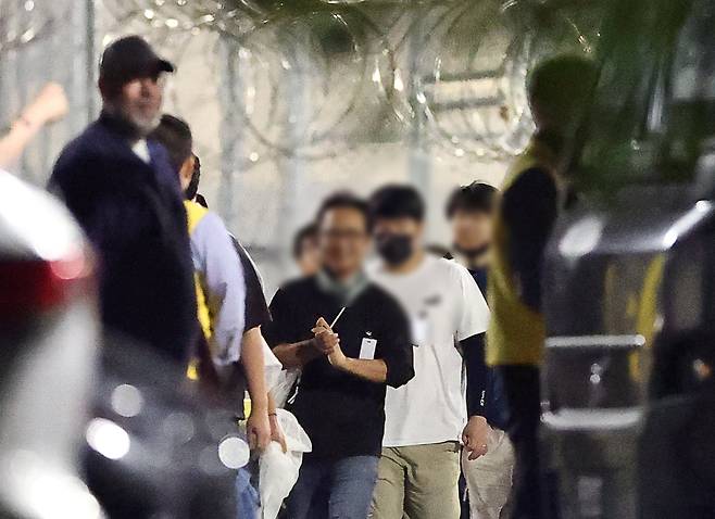 美 구금 시설서 나오는 한국인들 - 미국 조지아주 포크스턴의 이민세관단속국(ICE) 시설에 억류돼 있던 한국인들이 11일 새벽 밖으로 나오고 있다. 일행 중 일부가 안도한 듯 밝은 표정을 짓고 있다. 앞서 지난 4일 ICE 단속으로 조지아주 엘러벨의 현대차·LG에너지솔루션 합작 공장에서 한국인 317명을 포함해 총 475명이 체포됐다. 이들은 애틀랜타 하츠필드잭슨 공항에 도착해 있던 전세기 편으로 귀국 길에 올랐다. /연합뉴스