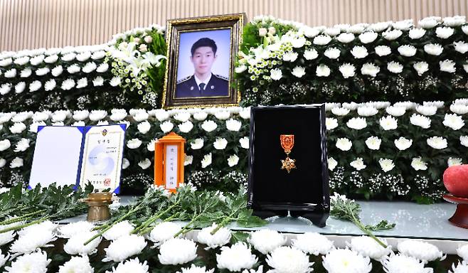 12일 인천 동구의 한 장례식장에 마련된 해양경찰관 고(故) 이재석 경사 빈소 영정 앞에 추서된 훈장이 놓여 있다. 연합뉴스