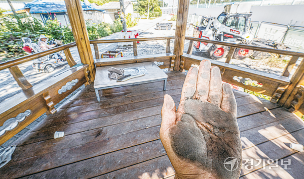 지난 10일 용인특례시 처인구 원삼면 용인반도체클러스터 일반산업단지 공사 현장 인근 마을 정자형 쉼터 바닥을 손으로 쓸자 시커먼 먼지가 묻어나고 있다. 조주현기자