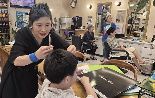 서울 은평구 역촌동에 있는 ‘안소영 미용실’의 안소영 원장이 16일 오후 정태율군의 머리카락을 다듬고 있다.