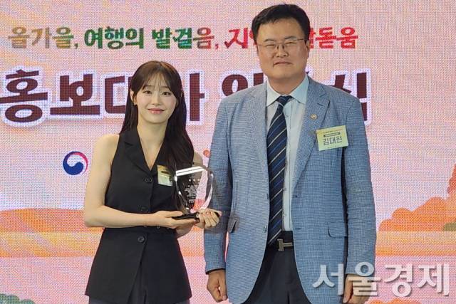 김대현(오른쪽) 문화체육관광부 제2차관이 16일 ‘2025 여행가는 가을’ 선포식에서 홍보대사 ‘츄’에게 위촉패를 전달한 뒤 기념촬영을 하고 있다. 최수문기자