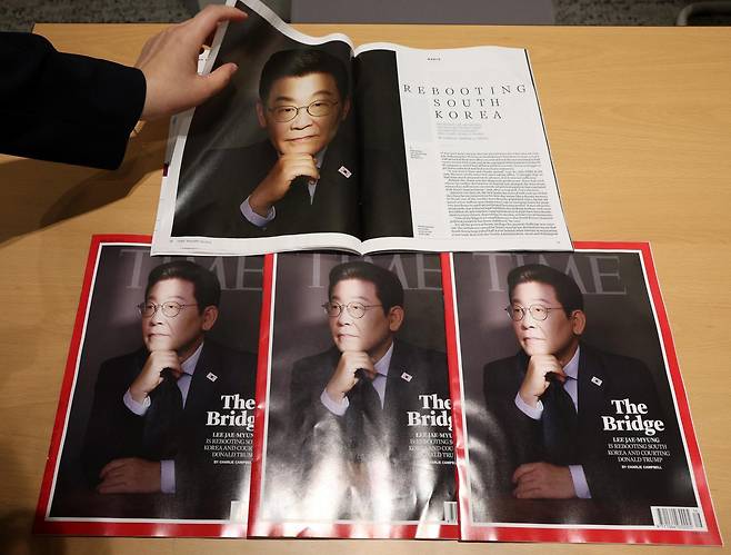 18일 이재명 대통령이 취임 100일을 맞아 지난 9월 3일 미국 타임 매거진 아시아지역 상임편집장 찰리 캠벨과 특집 기사 인터뷰를 진행했다고 대통령실이 18일 밝힌 가운데 대통령실 관계자들이 타임 매거진을 살펴보고 있다. 표지의 제목은 ‘가교(The Bridge): 이재명 대통령이 한국을 리부트(재가동)하다’이다. 2025.09.18. 뉴시스