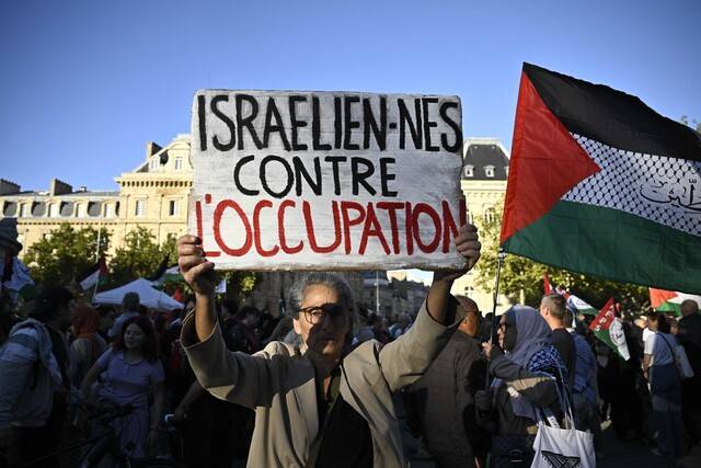 17일(현지시각) 프랑스 파리 레퓌블리크 광장에서 열린 ‘제노사이드(인종청소)를 멈추라’ 집회에서 한 시민이 ‘점령에 반대하는 이스라엘인’이라는 팻말을 들고 있다. AFP 연합뉴스