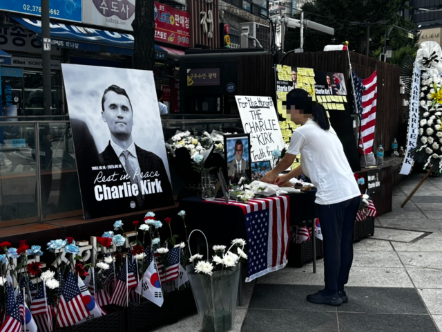 지난 15일 서울 숭례문 앞 조성된 찰리 커크 추모 공간에 한 시민이 조화를 올리며 추모하고 있다. 노지운 기자