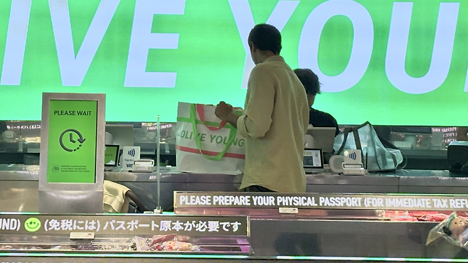 지난 17일 올리브영 명동 타운점에서 한 외국인 관광객이 타포린백에 구매한 물건을 옮겨담고 있다. 박연수 기자