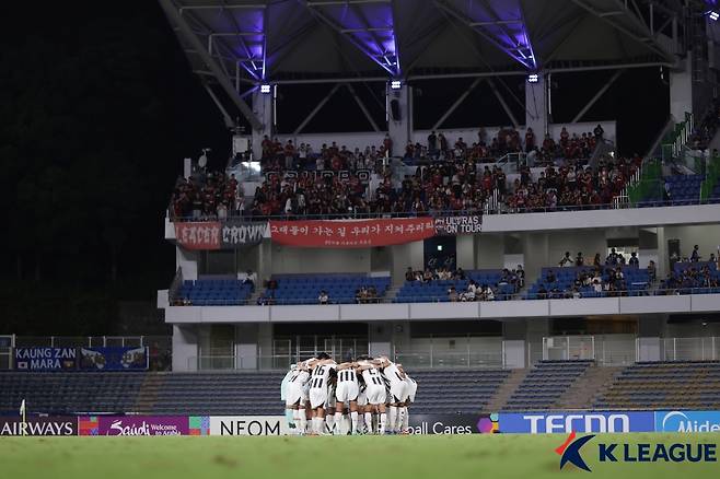 지난 16일 일본 마치다 애슬레틱 스타디움에서 열린 마치다 젤비아와의 2025~2026 아시아축구연맹(AFC) 챔피언스리그 엘리트(ACLE) 리그 스테이지 1차전을 앞두고 의지를 다지고 있는 FC선수들. 사진 상단은 원정 응원에 나선 서울 서포터스. /사진=한국프로축구연맹 제