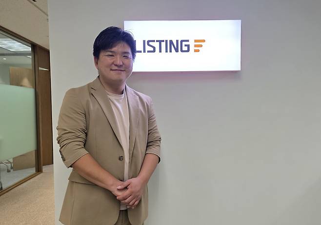 리스팅 로고 앞에서 선 김재윤 대표. 사진=김재윤