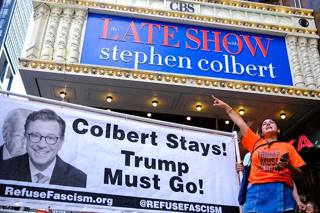지난 7월 미국 뉴욕시 한 극장 앞에서 시민들이 "콜베어는 남아라! 트럼프는 물러가라!"라는 플래카드를 들고 시위를 하고 있다. 당시 CBS는 콜베어가 진행하는 자사 토크쇼가 2026년 종료될 예정이라고 밝혔다. /AFP 연합뉴스