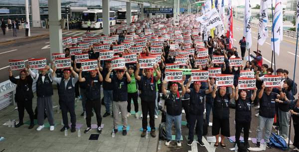 전국공항노동자연대가 19일 인천 영종도 인천국제공항 제2여객터미널에서 연 총파업 대회에서 참가자들이 손팻말을 들고 있다. 전국공항노동자연대는 이날 경고 파업을 진행한 후 추석 연휴 전 무기한 총파업을 진행할 것이라고 예고했다. 연합뉴스