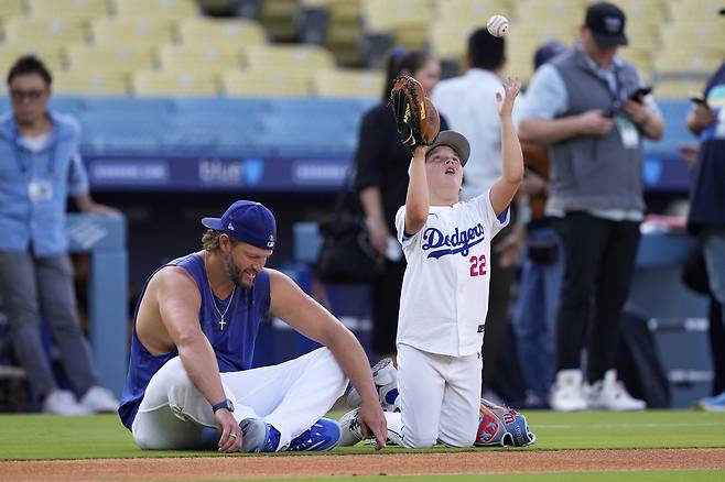 19일 은퇴를 선언한 LA 다저스 클레이턴 커쇼가 이날 경기 전 아들과 함께 다저스타디움 그라운드 위에 앉아있다. AP연합뉴스