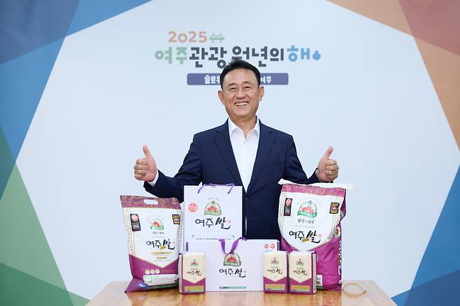 이충우 여주시장이 4년 만에 조기 완판된 다양한 크기의 '대왕님표 여주쌀' 포장미를 앞에 놓고 엄지를 들어올리며 '으뜸'을 표현하고 있다. 사진=여주시청