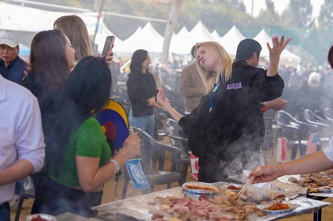 27일 오전 10시 30분 증평인삼골 축제장에 오면 홍삼 포크 삼겹살을 무료로 맛볼 수 있다. 사진은 지난해 축제 때 삼겹살을 즐기며 사진을 찍는 외국 관광객의 모습. 증평군 제공
