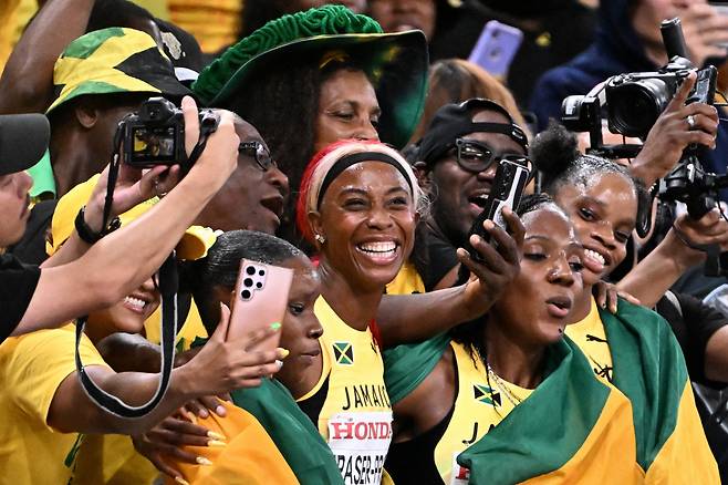 셸리앤 프레이저 프라이스(가운데)가 지난 21일 일본 도쿄에서 열린 세계육상선수권 여자 4x100m 계주 결승을 마친 뒤 동료들과 함께 기념 촬영을 하고 있다. AFP연합뉴스