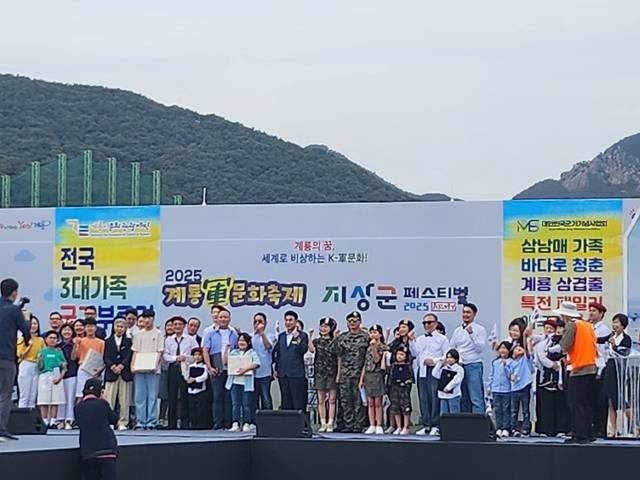 지난 19일 오후 계룡군문화축제 무대에서 열린 전국 3대가족 군가부르기대회 참가자들이 무대에서 기념촬영하고 있다. 대한민국 군가기념사업회 제공