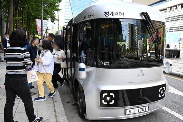 국내 최초 운전석 없는 자율주행 셔틀버스 '청계A01' 정식 운행 첫날인 23일 시민들이 정차한 차량을 살펴보고 있다. 서울시 제공