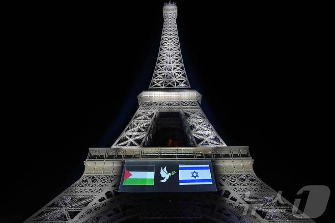 파리 에펠탑에 팔레스타인(왼쪽)과 이스라엘(오른쪽) 국기, 그리고 올리브 가지를 문 부리에 물고 있는 비둘기 이미지가 투사되고 있다. 2025.09.22. ⓒ AFP=뉴스1