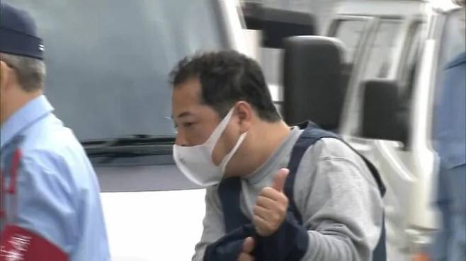 준강제성교죄 등 혐의로 기소된 게스트하우스 사장 다케우치 도시하루(51)가 2022년 검찰 송치 당시 취재진 카메라를 향해 엄지를 치켜세운 모습./TBS뉴스 캡처