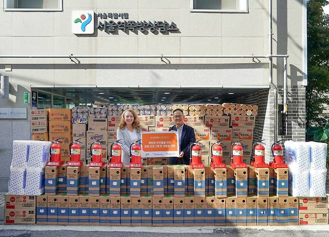 서울 용산구 서울역쪽방상담소에서 열린 ‘문화 프로그램 지원금 및 생필품 전달식’에서 JTI코리아 이리나 리 사장과 서울역쪽방상담소 전익형 실장이 기념 촬영을 하고 있다.JTI코리아 제공