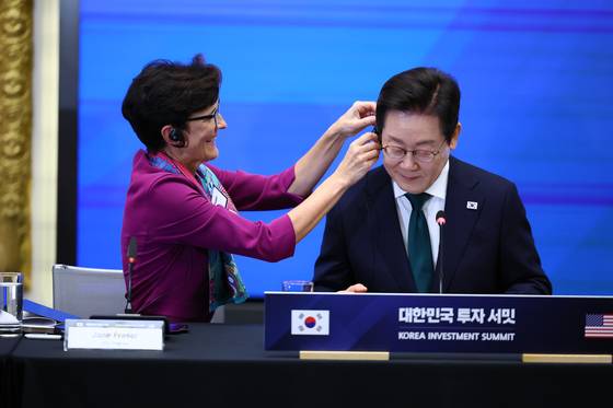 이재명 대통령이 25일(현지시간) 미국 뉴욕 증권거래소에서 열린 한국경제설명회 투자서밋에서 제인 프레이저 씨티그룹 회장의 도움을 받아 통역기를 착용하고 있다. 김현동 기자