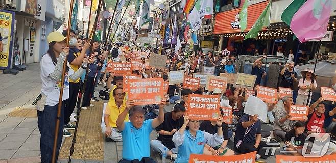 27일 오후 부산 서면 하트조형물에서 열린 기후정의행진 집회에서 참가자가 피켓을 들고 구호를 외치고 있다. 2025.9.27/뉴스1 ⓒ News1 김태형 기자