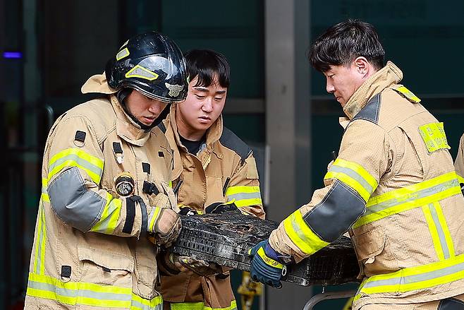 27일 대전 유성구 국가정보자원관리원(국정자원)에서 소방대원이 불에 탄 배터리를 옮기고 있다. 연합뉴스