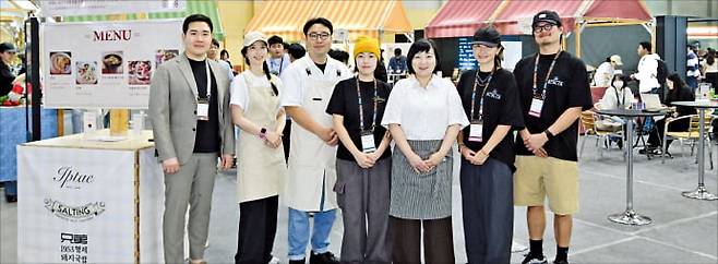 박상화 푸드트래블 대표(맨 왼쪽)가 플라이 아시아에 마련한 식음 브랜드관 앞에서 5개 로컬 브랜드 사장들과 함께 포즈를 취하고 있다. 부산기술창업투자원 제공