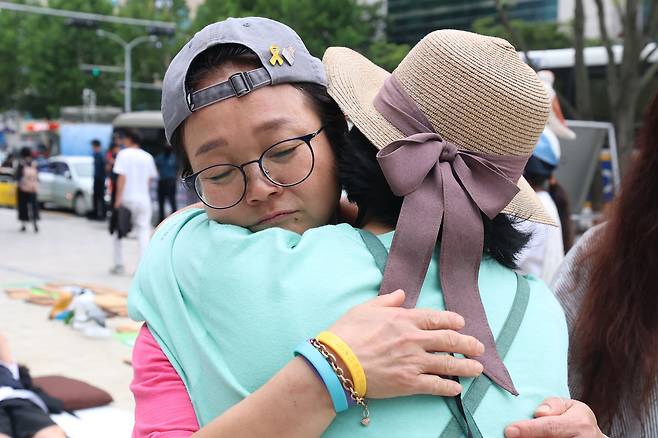 주휘씨가 서울행정법원을 떠나 세종호텔로 이동하기 전 동료와 포옹하고 있다.