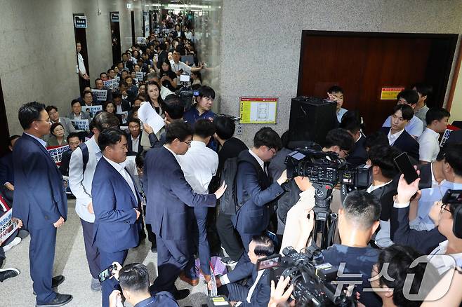 국민의힘 의원들이 지난달 3일 오후 서울 여의도 국회 국민의힘 원내대표실 앞에서 긴급 의원총회를 가진 가운데 내란특검 수사관들이 원내대표실 압수수색에 실패한 후 국회를 나서고 있다./뉴스1 ⓒ News1 신웅수 기자