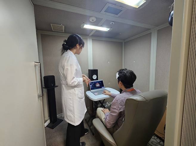 삼성서울병원이 진행한 소음 제거 기능 관련 연구에서 참가자가 뇌혈류 측정 장치를 쓰고 과제 수행에 관한 설명을 듣고 있다. 삼성서울병원 제공