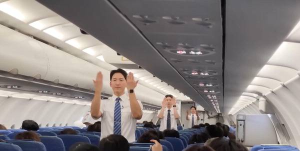 남성으로만 구성된 에어부산 기내 승무원이 승객에게 안전수칙을 설명하고 있다. 에어부산 제공