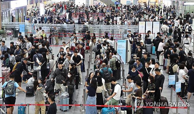 추석 연휴 맞아 붐비는 김해공항 국제선 출국장 (부산=연합뉴스) 강선배 기자 = 2일 오전 부산 강서구 김해국제공항 국제선 출국장에서 추석 연휴를 이용해 해외여행을 떠나는 여행객들이 길게 줄을 선 채 출국수속을 기다리고 있다. 2025.10.2 sbkang@yna.co.kr