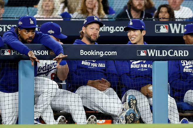 LA 다저스 김혜성이 지난 1일(한국시각) 열린 신시내티 레즈와의 와일드카드시리즈 1차전을 벤치에서 클레이튼 커쇼와 함께 지켜보며 이야기를 나누고 있다. AFP연합뉴스