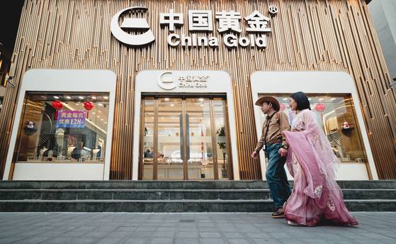 지난 4월 상하이의 한 황금 소매상점 앞을 한 시민이 지나고 있다. 중국 중앙은행인 인민은행은 지난 2년 사이에 황금보유량을 124.7 t 늘리면서 외환보유액 중 황금 비중을 4.28%에서 7.64%로 늘렸다. EPA=연합뉴스
