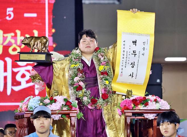 8일 울산 울주종합체육센터에서 열린 ‘위더스제약 2025 울주추석장사씨름대회’ 백두장사(140kg이하)에 등극한 김민재(영암군민속씨름단)가 장사인증서와 황소트로피를 들고 기념사진을 찍고 있다. 대한씨름협회 제공