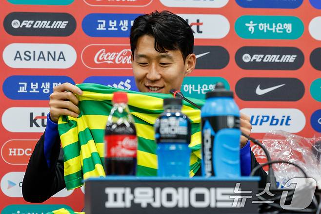 대한민국 남자 축구 국가대표팀 손흥민 선수가 9일 오후 서울 마포구 월드컵경기장에서 브라질과의 A매치 평가전을 하루 앞두고 공식 기자회견을 하던 중 브라질 취재진으로부터 사탕과 옷을 선물받고 있다. 2025.10.9/뉴스1 ⓒ News1 안은나 기자