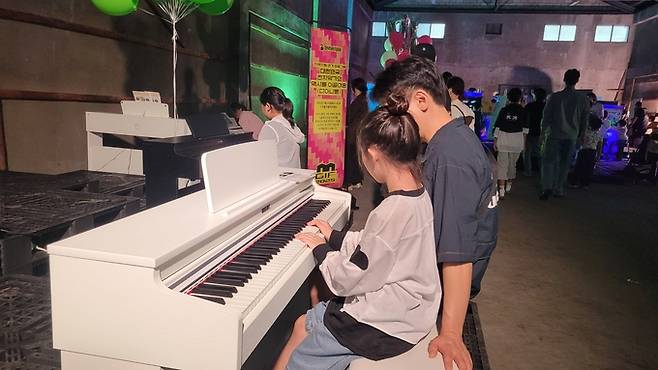 ▲ 2025 구미산단페스티벌에 관람온 부녀가 전자 피아노를 치고 있다. 이봉한기자