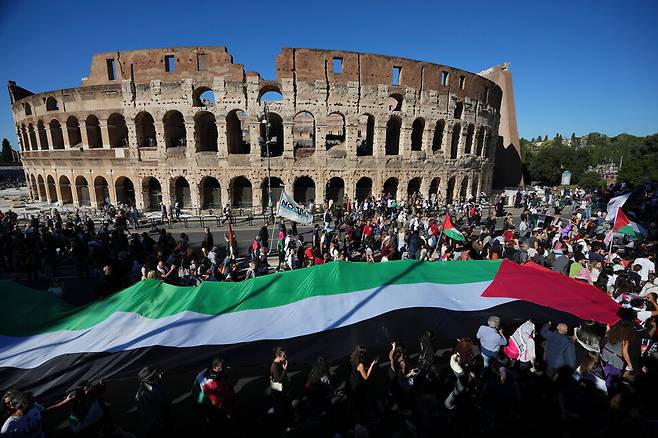 팔레스타인 지지자들이 4일(현지시각) 이스라엘의 가자 지구 공격으로 고통을 받는 팔레스타인 주민들을 위해 이탈리아 로마에 있는 콜로세움 앞을 지나 행진하고 있다. 이탈리아 로마에서는 나흘째 이스라엘 규탄시위가 계속됐다. 이날 집회에는 약 40만명이 참가했다. 로마/AP 연합뉴스