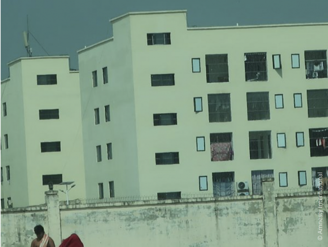 철조망 또는 예리한 금속 조각이 붙은 철선이 3중으로 쳐져 있는 사기 시설의 높은 벽 뒤로 쇠창살이 설치된 창문들이 보인다. 국제앰네스티 홈페이지