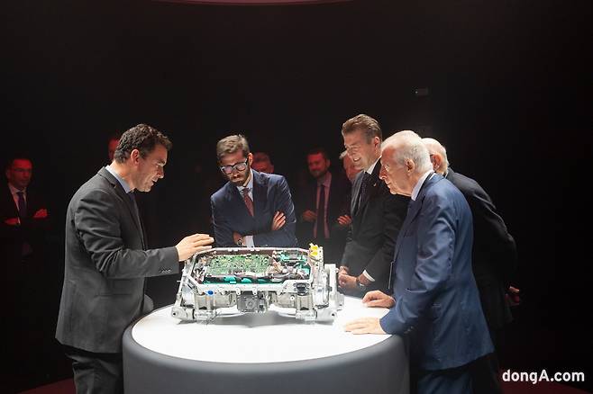 페라리 임원진들이 전기차 부품을 살펴보고 있다.