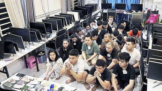 지난 7월 캄보디아 시아누크빌의 한 빌딩에서 수사 당국에 검거된 온라인 사기조직 용의자들이 포승줄에 묶여 범행 현장에 앉아 있다. AP=연합뉴스