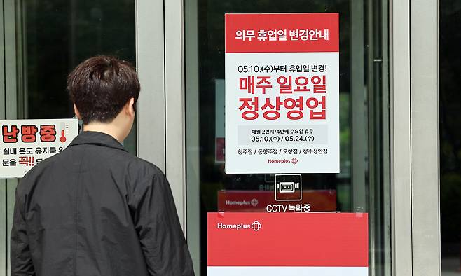 2023년 5월 한 대형마트에서 시민이 출입문에 붙은 휴업일 변경 안내문을 보고 있다. 연합뉴스