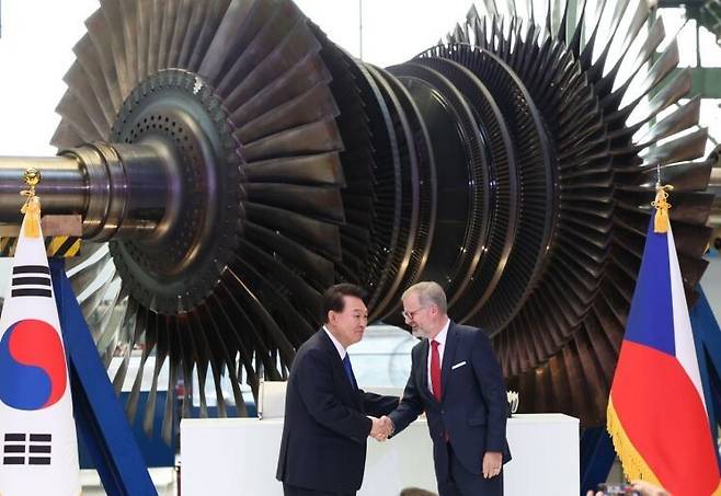 윤석열 전 대통령이 지난해 9월 체코 플젠 산업단지 내 두산스코다파워 공장에서 페트로 피알라 체코 총리와 악수하고 있다. 연합뉴스