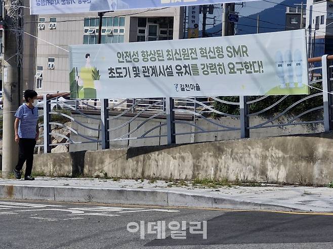 길천마을 한 주민이 지난 1일 소규모모듈원전(SMR) 유치를 촉구하는 현수막을 걸어가고 있다. (사진=최훈길 기자)